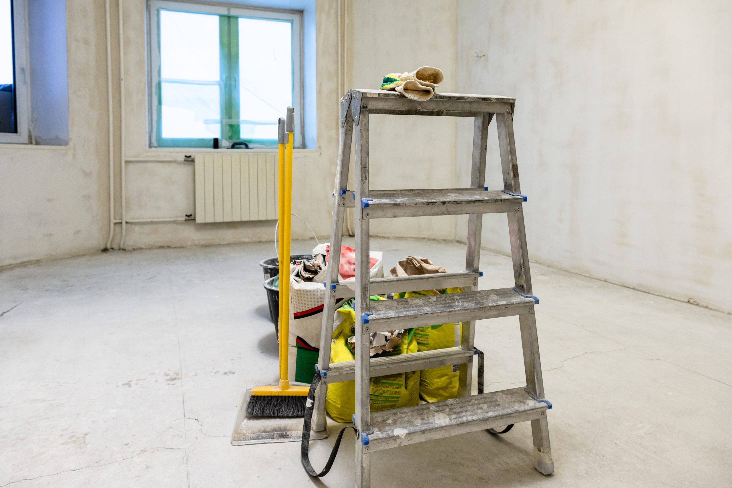 plasterer's tools in room with rough finishing