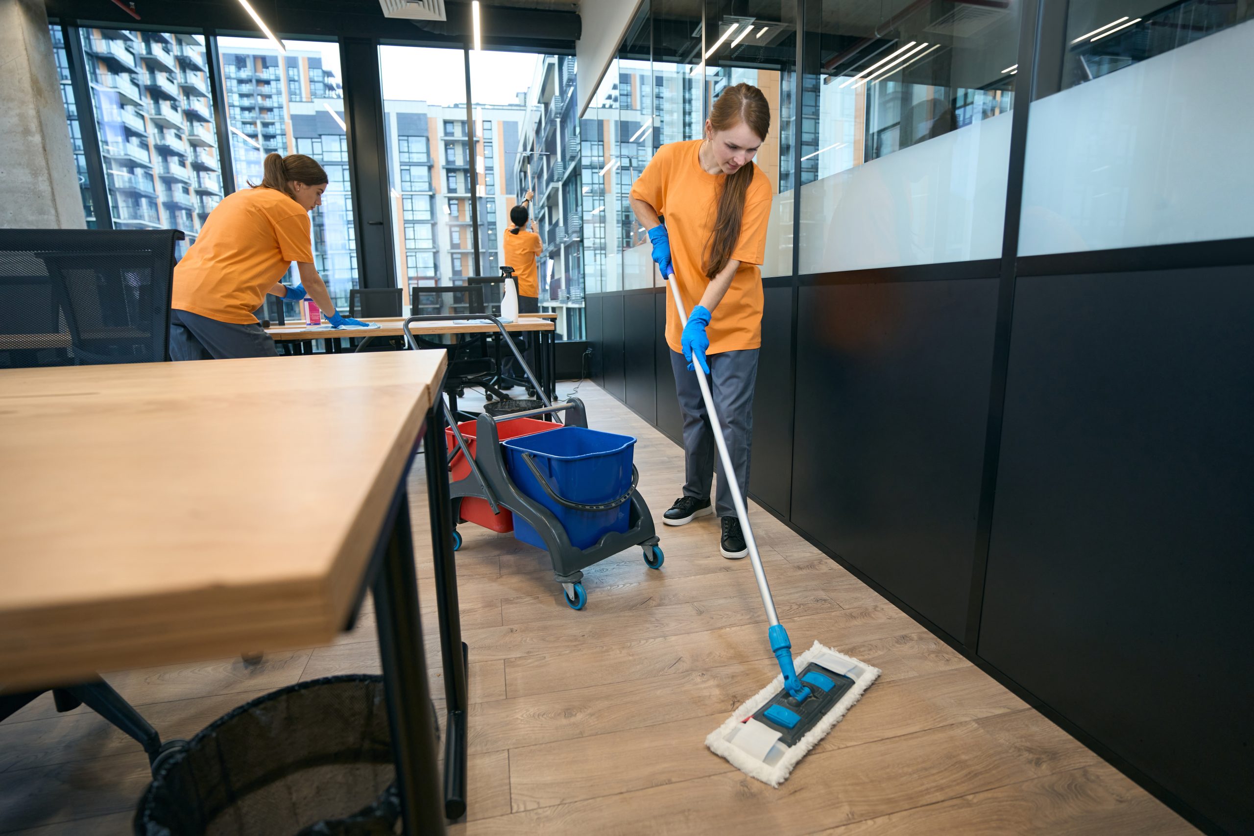 team of cleaners work in coworking area, women clean all surfaces
